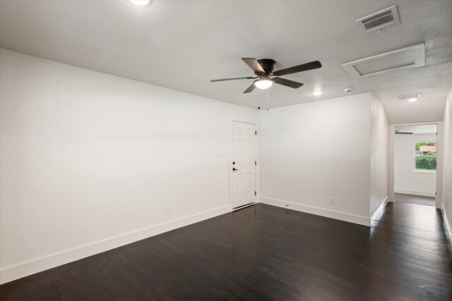 spare room with baseboards, visible vents, dark wood finished floors, and attic access