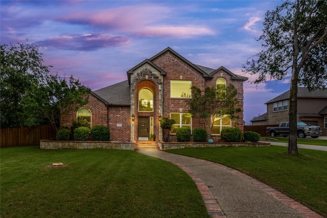 view of front of property with fence, a front lawn, a shingled roof, and brick siding