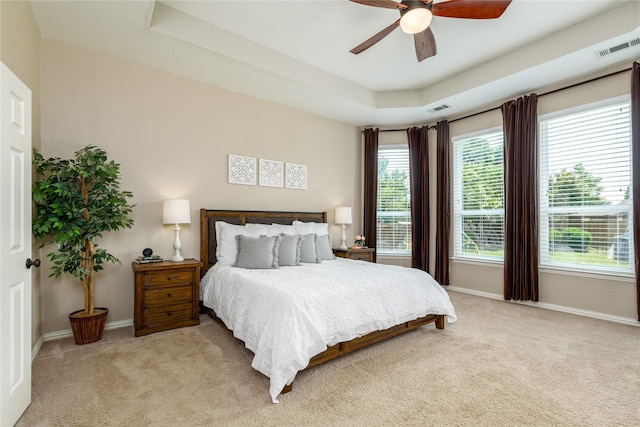 bedroom with visible vents, multiple windows, light colored carpet, and baseboards