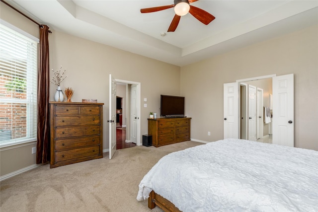 bedroom featuring multiple windows, light colored carpet, and baseboards