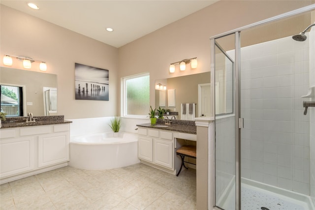bathroom featuring a garden tub, a shower stall, tile patterned flooring, and a sink