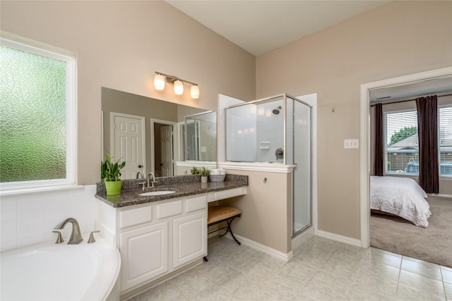 ensuite bathroom with tile patterned floors, a bath, vanity, baseboards, and a stall shower