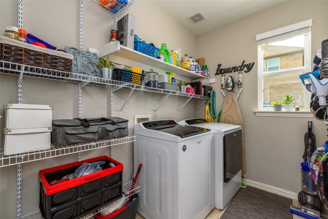 washroom featuring visible vents, baseboards, laundry area, and washer and clothes dryer