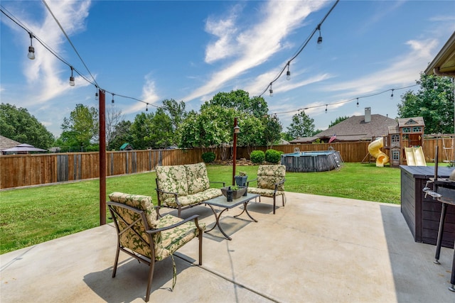 view of patio with an outdoor living space, a playground, and a fenced backyard