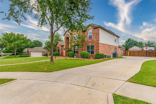 traditional-style house featuring a front yard, driveway, central AC, brick siding, and fence