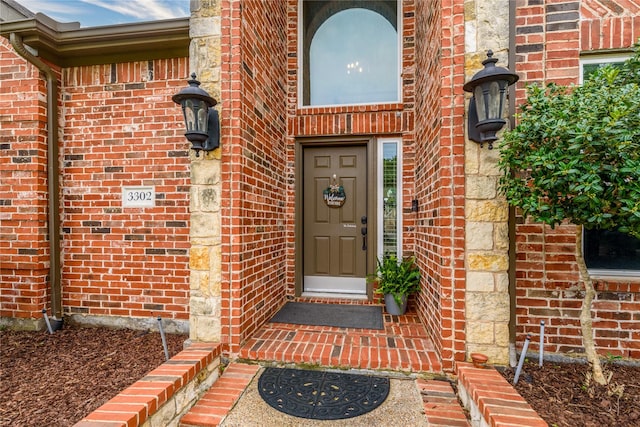 doorway to property featuring brick siding
