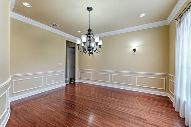 unfurnished room with crown molding, visible vents, wood finished floors, a notable chandelier, and wainscoting