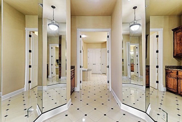 interior space featuring baseboards and light tile patterned flooring