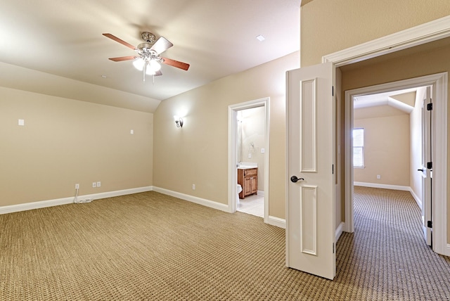 additional living space featuring light colored carpet, ceiling fan, vaulted ceiling, and baseboards