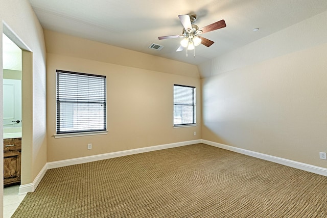 spare room with visible vents, ceiling fan, light colored carpet, and baseboards