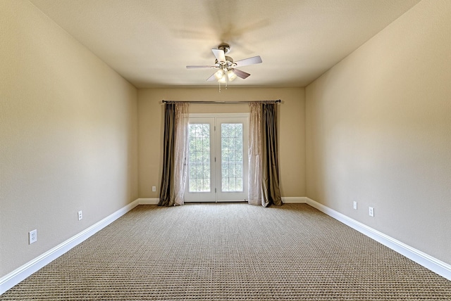 carpeted spare room with ceiling fan and baseboards