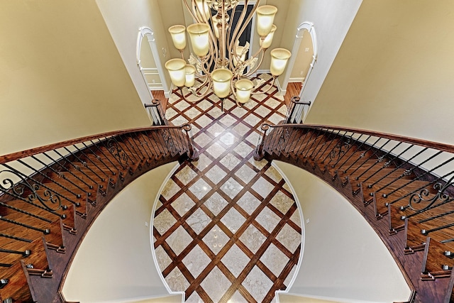 stairs featuring an inviting chandelier and a high ceiling