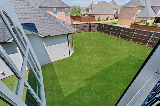 view of yard featuring a fenced backyard and a residential view