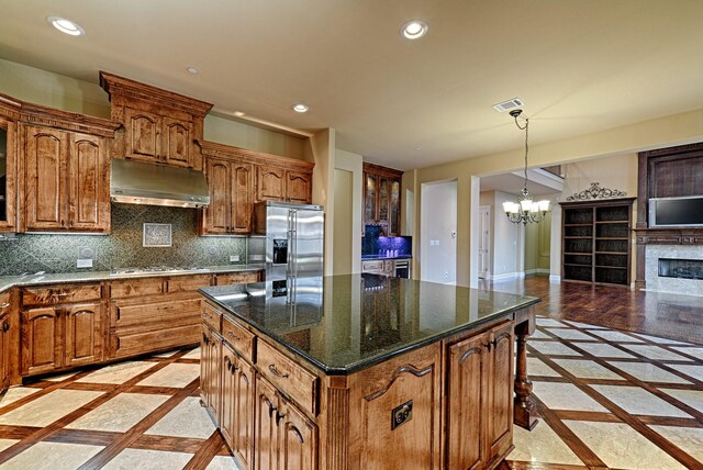 kitchen with recessed lighting, an inviting chandelier, stainless steel appliances, under cabinet range hood, and visible vents