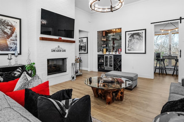 living area with an inviting chandelier, wood finished floors, a bar, and baseboards