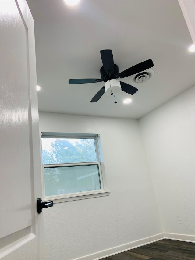 spare room featuring dark wood-style flooring and baseboards