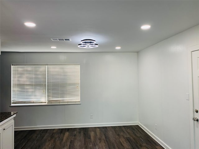 unfurnished room with dark wood-type flooring, visible vents, recessed lighting, and baseboards