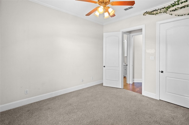 unfurnished bedroom featuring carpet floors, ornamental molding, ceiling fan, baseboards, and visible vents