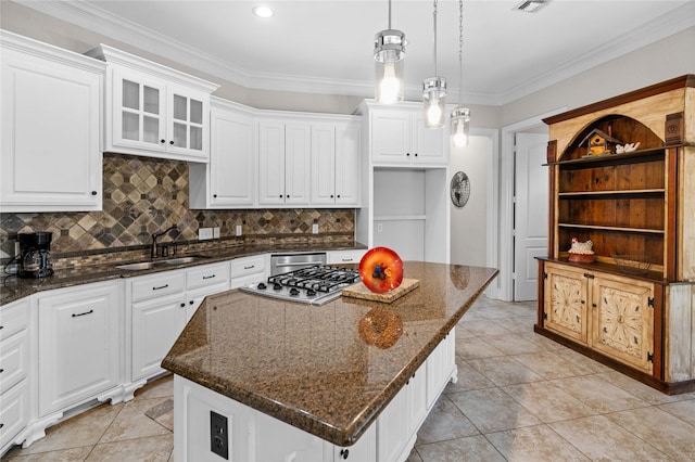 kitchen featuring tasteful backsplash, stainless steel gas cooktop, open shelves, a sink, and a center island