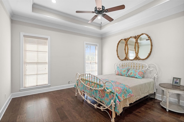 bedroom featuring a raised ceiling, hardwood / wood-style floors, crown molding, and baseboards