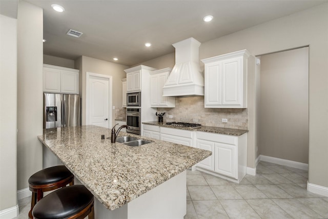 kitchen with visible vents, a sink, light stone counters, custom exhaust hood, and stainless steel appliances