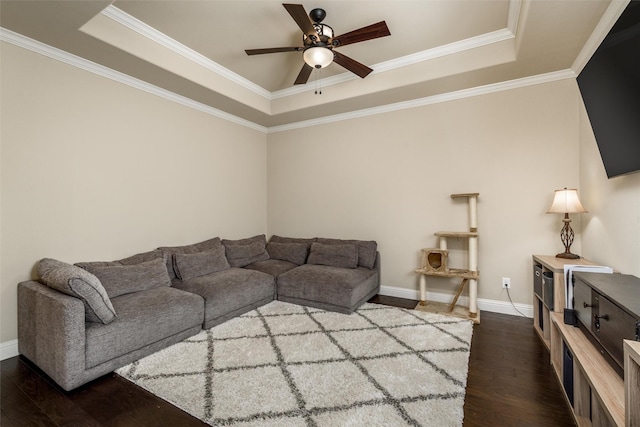 living area with a raised ceiling, ornamental molding, a ceiling fan, and dark wood finished floors