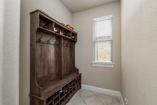 mudroom with baseboards, plenty of natural light, and light tile patterned floors