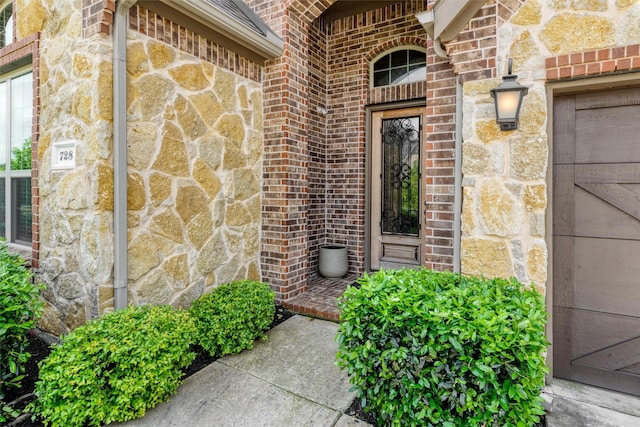doorway to property with brick siding and stone siding