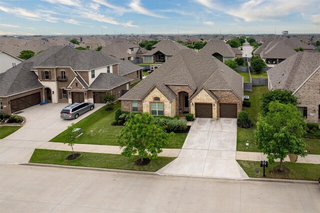 french provincial home with concrete driveway, brick siding, a residential view, and a garage