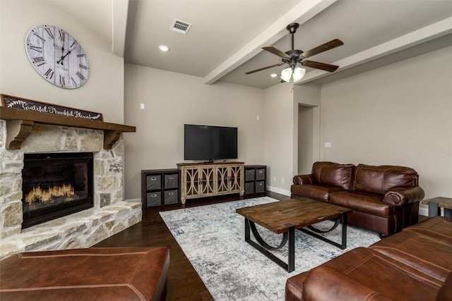 living room with ceiling fan, beam ceiling, a fireplace, wood finished floors, and visible vents