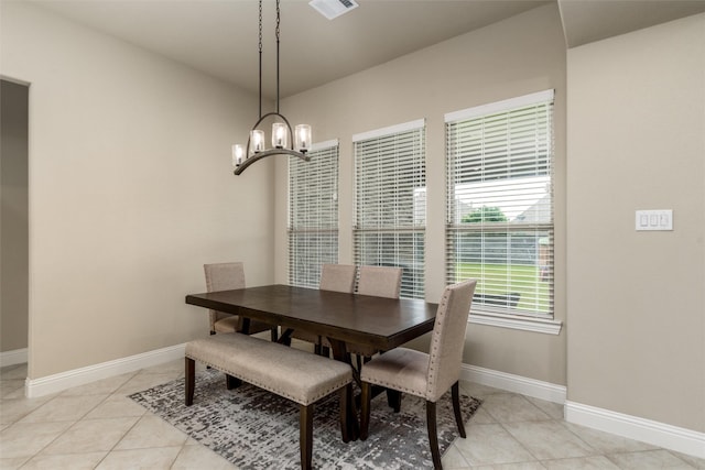 dining space with baseboards, a chandelier, light tile patterned floors, and visible vents