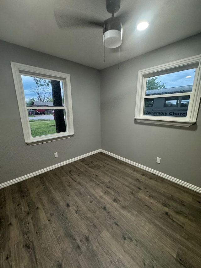 empty room featuring a ceiling fan, wood finished floors, and baseboards
