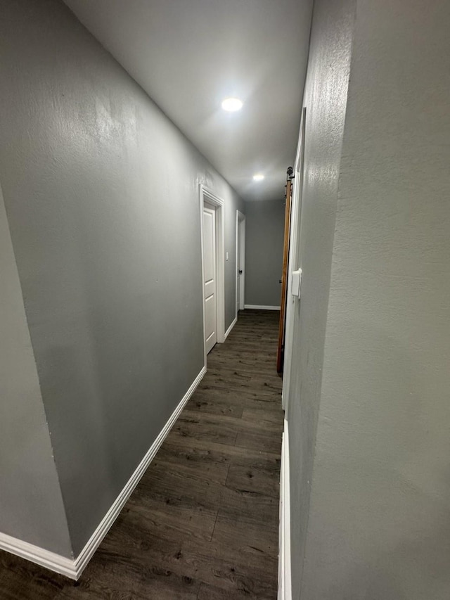 hallway with dark wood-style floors, baseboards, and recessed lighting