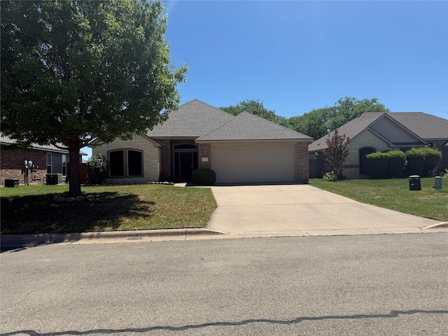 ranch-style home with a garage, brick siding, a front lawn, and driveway