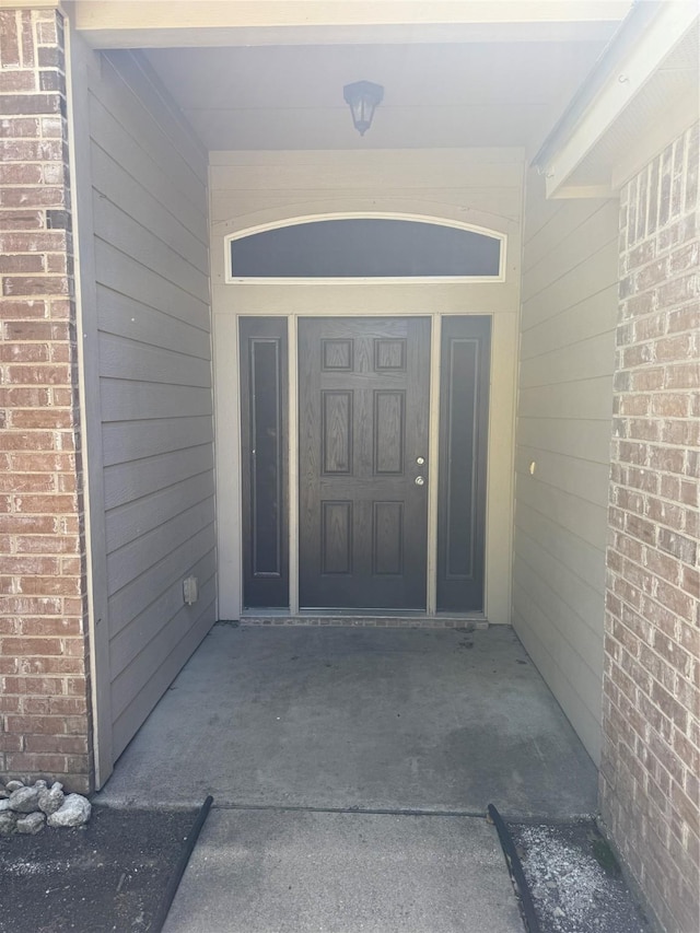 doorway to property featuring brick siding