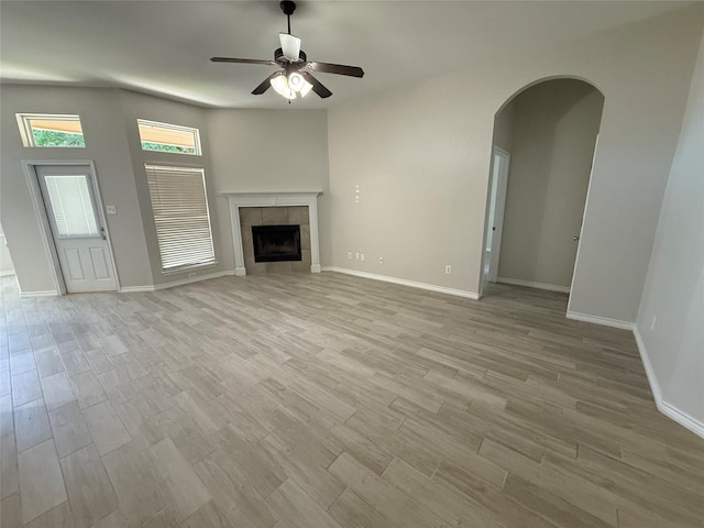 unfurnished living room featuring baseboards, ceiling fan, and light wood-style flooring