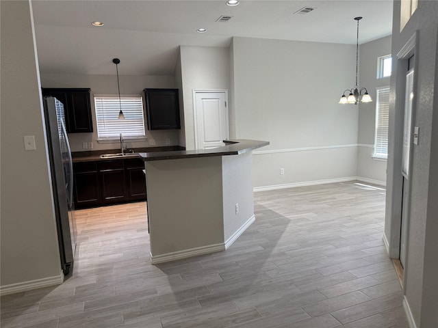 kitchen with plenty of natural light, a sink, freestanding refrigerator, and visible vents