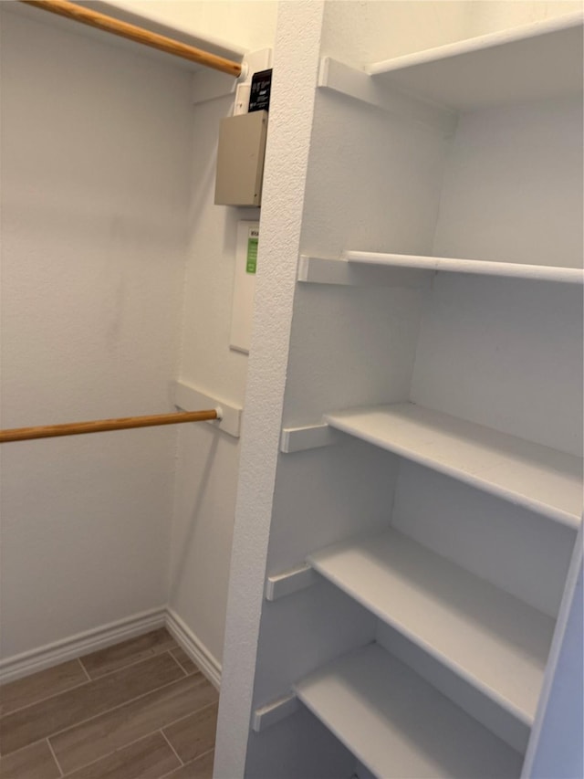walk in closet with wood finished floors