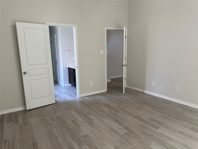 unfurnished bedroom featuring wood finished floors and baseboards