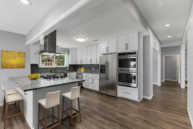 764 Cardinal Ln, Coppell, TX 75019 - kitchen with appliances with stainless steel finishes, range hood, a kitchen breakfast bar, white cabinetry, and decorative backsplash