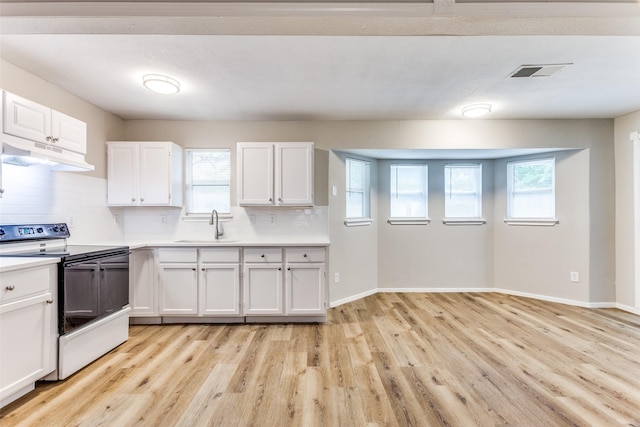 1601 Winderemere Dr, Arlington, TX 76014 - kitchen with black range with electric stovetop, a sink, light countertops, under cabinet range hood, and white cabinetry