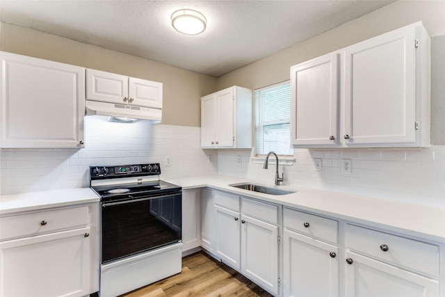 1601 Winderemere Dr, Arlington, TX 76014 - kitchen with electric range, a sink, light countertops, white cabinets, and under cabinet range hood