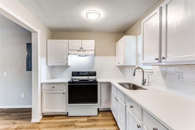 1601 Winderemere Dr, Arlington, TX 76014 - kitchen with black / electric stove, a sink, light countertops, under cabinet range hood, and white cabinetry