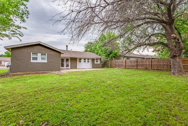 1601 Winderemere Dr, Arlington, TX 76014 - rear view of house with a yard, brick siding, fence, and a patio area