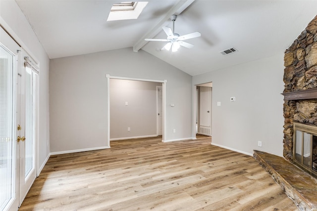 1601 Winderemere Dr, Arlington, TX 76014 - unfurnished living room featuring vaulted ceiling with skylight, ceiling fan, visible vents, a fireplace, and light wood-type flooring