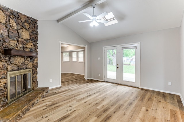 1601 Winderemere Dr, Arlington, TX 76014 - unfurnished living room featuring vaulted ceiling with skylight, a fireplace, a ceiling fan, baseboards, and wood finished floors