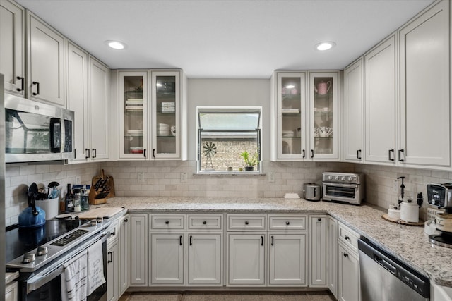 kitchen featuring light stone countertops, stainless steel appliances, recessed lighting, and decorative backsplash
