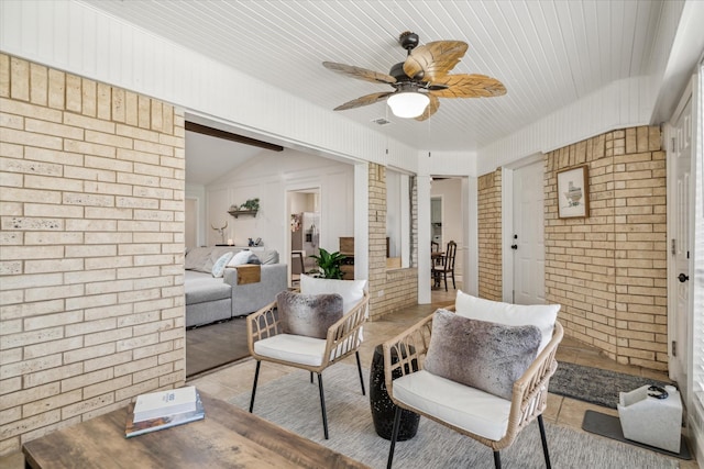 interior space with a ceiling fan, brick wall, and wood ceiling