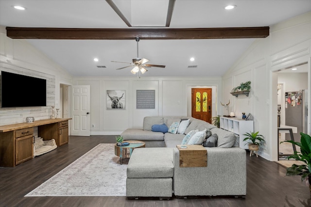living room with dark wood-style floors, lofted ceiling with beams, ceiling fan, visible vents, and a decorative wall