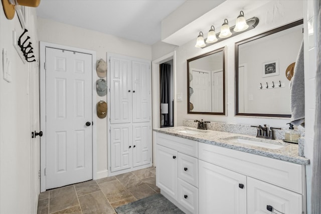 full bathroom featuring double vanity, a sink, and stone finish flooring